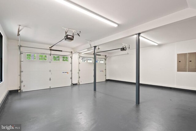  - garage featuring electric panel, baseboards, and a garage door opener