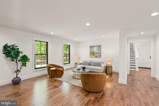  - living area with light wood finished floors, stairs, baseboards, and recessed lighting