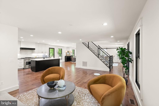  - living room featuring recessed lighting, baseboards, visible vents, stairs, and light wood-style floors