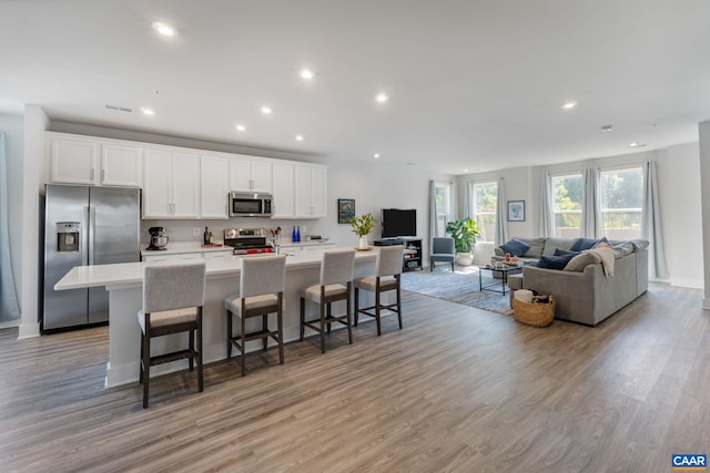 802 Wesley Ln Unit B, Charlottesville, VA 22911 - kitchen with appliances with stainless steel finishes, a large island, open floor plan, light wood-style flooring, and recessed lighting