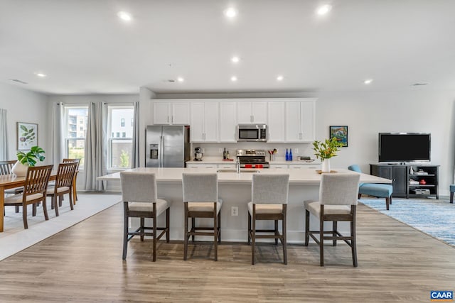 802 Wesley Ln Unit B, Charlottesville, VA 22911 - kitchen with appliances with stainless steel finishes, a kitchen island with sink, white cabinets, light countertops, and recessed lighting