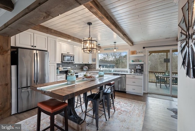 26438 Pennfields Dr, Orange, VA 22960 - kitchen featuring a chandelier, beamed ceiling, stainless steel appliances, white cabinets, and dark wood-style floors