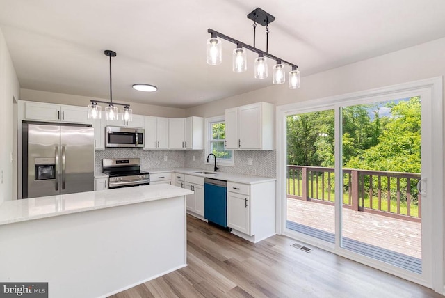 8452 Turnbull Rd, Warrenton, VA 20186 - kitchen with stainless steel appliances, a sink, backsplash, white cabinets, and wood finished floors