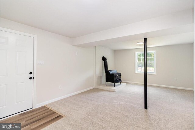 8452 Turnbull Rd, Warrenton, VA 20186 - basement with a wood stove, baseboards, and light carpet