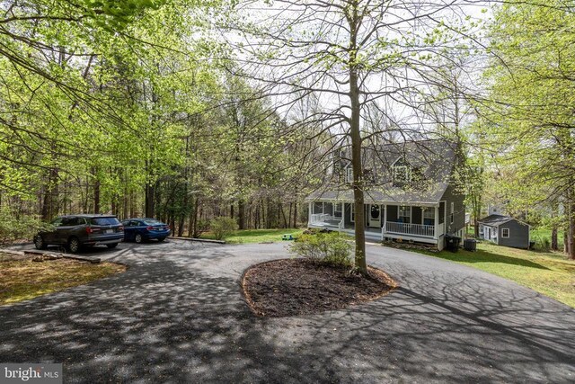 372 Daniels Rd, Barboursville, VA 22923 - view of front of property with curved driveway, covered porch, a front yard, and a forest view