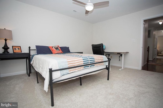 bedroom with light colored carpet, baseboards, and ceiling fan