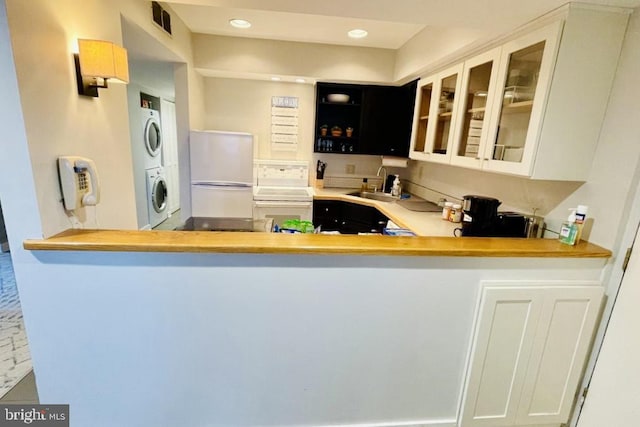 1421 Highlands, Roseland, VA 22967 - kitchen featuring white appliances, estacked washer and dryer, a sink, glass insert cabinets, and recessed lighting