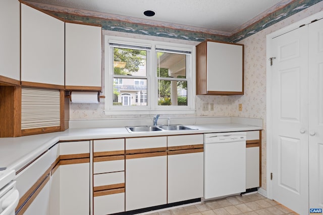 1184 Partridge Ln, Charlottesville, VA 22901 - kitchen featuring dishwasher, wallpapered walls, a sink, light countertops, and white cabinets