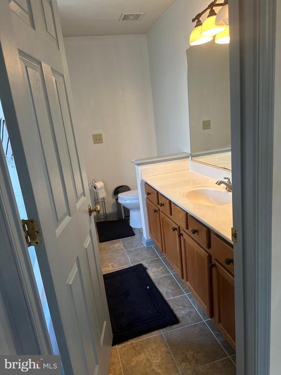 6015 Sunny Meadows Dr, Fredericksburg, VA 22407 - half bathroom with toilet, vanity, and tile patterned flooring