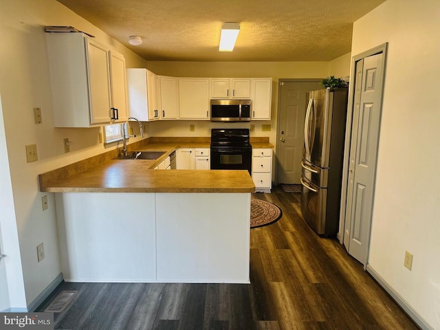 6015 Sunny Meadows Dr, Fredericksburg, VA 22407 - kitchen with appliances with stainless steel finishes, dark wood-style flooring, a peninsula, white cabinetry, and a sink