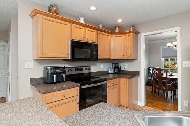30 Beatrice Ct, Fishersville, VA 22939 - kitchen with black microwave, stainless steel electric range, light wood-style floors, a chandelier, and crown molding