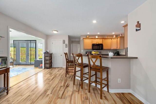 30 Beatrice Ct, Fishersville, VA 22939 - kitchen with black microwave, light wood-type flooring, recessed lighting, dark countertops, and a kitchen bar