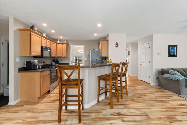 30 Beatrice Ct, Fishersville, VA 22939 - kitchen featuring stainless steel appliances, light wood finished floors, dark countertops, a kitchen bar, and open floor plan