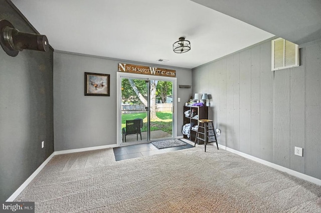  - unfurnished room featuring carpet flooring and wooden walls