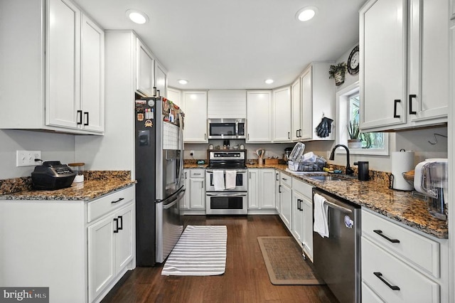  - kitchen with stainless steel appliances, white cabinets, dark wood-style flooring, dark stone counters, and recessed lighting