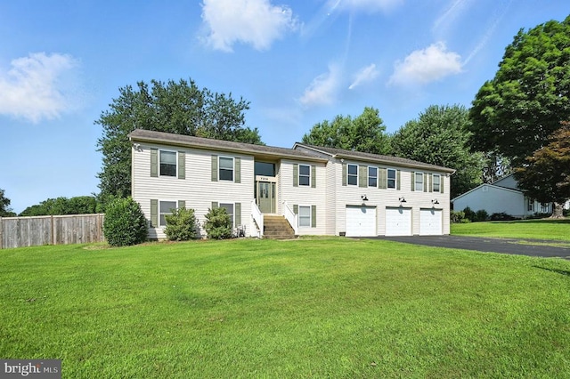  - split foyer home featuring asphalt driveway and an attached garage