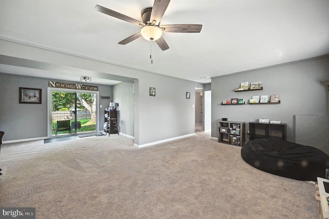  - carpeted living area with baseboards and ceiling fan