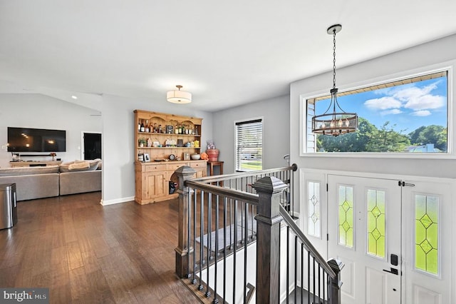  - corridor with an upstairs landing, a chandelier, and dark wood-style floors