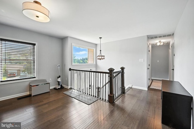  - hall featuring an upstairs landing and dark wood-style flooring