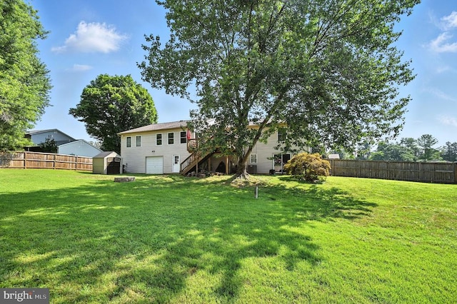  - fenced backyard with stairway, a storage unit, and a garage