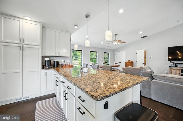  - kitchen featuring open floor plan, a peninsula, dark wood-style flooring, vaulted ceiling, and white cabinets