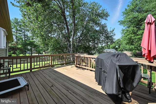  - wooden deck featuring a grill and a lawn