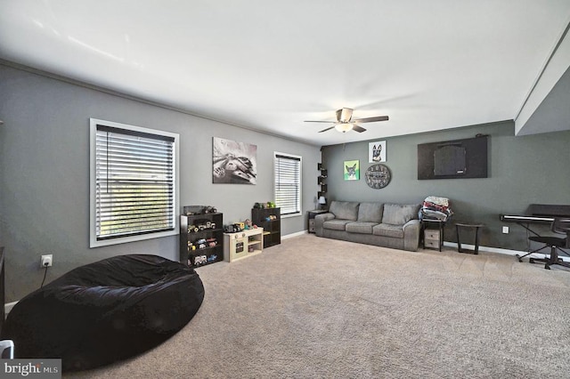  - carpeted living area with ceiling fan and baseboards