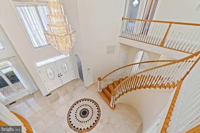 3714 Fairways Ct, Fredericksburg, VA 22408 - foyer featuring a towering ceiling, a chandelier, arched walkways, baseboards, and plenty of natural light