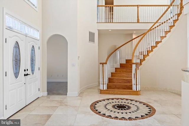 3714 Fairways Ct, Fredericksburg, VA 22408 - foyer featuring a towering ceiling, baseboards, arched walkways, stairway, and inlaid floor details
