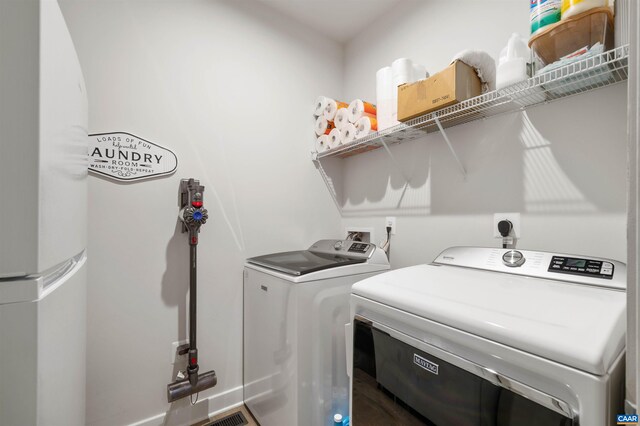 laundry room with washer and clothes dryer and baseboards