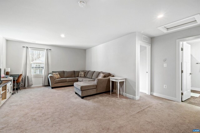 carpeted living area featuring baseboards, recessed lighting, and attic access