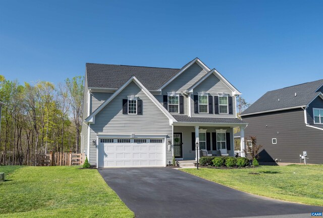 view of front of property with a porch, aphalt driveway, fence, and a front yard