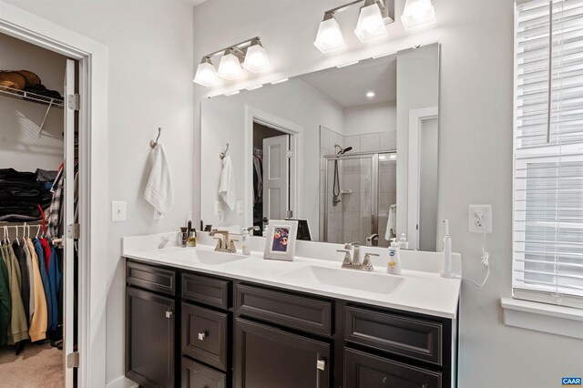 full bath featuring a shower stall, double vanity, and a spacious closet
