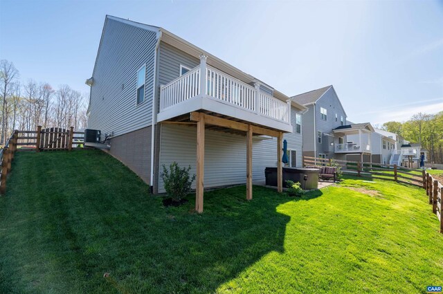 rear view of property featuring a hot tub, a deck, and central air condition unit