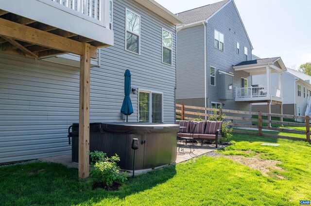 rear view of property featuring a hot tub and a patio area