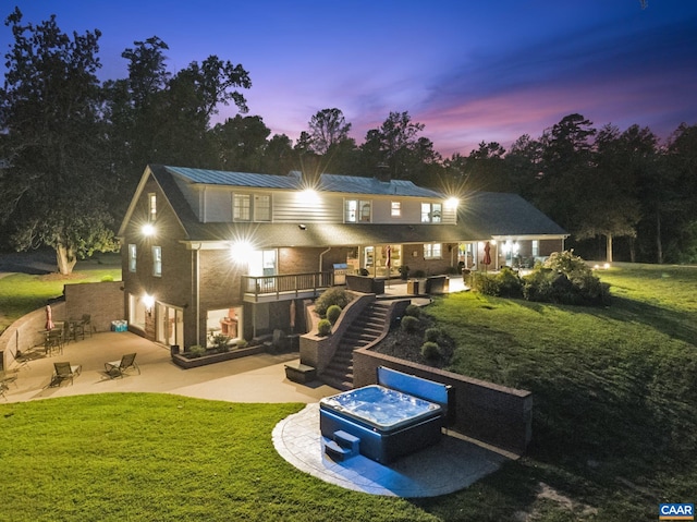 6904 James Madison Hwy, Fork Union, VA 23055 - back of property at dusk featuring metal roof, a garage, a patio, and a lawn