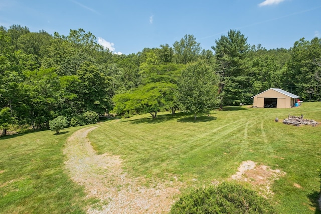554 Harris Cove Ln, Elkton, VA 22827 - view of grassy yard featuring a garage, an outbuilding, and a forest view