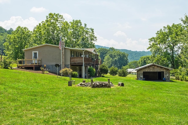 554 Harris Cove Ln, Elkton, VA 22827 - view of grassy yard featuring a detached garage, a deck, an outdoor fire pit, and an outbuilding