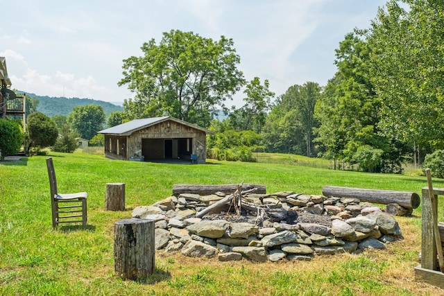 554 Harris Cove Ln, Elkton, VA 22827 - view of green lawn with a fire pit, a detached garage, an outbuilding, and an outdoor structure