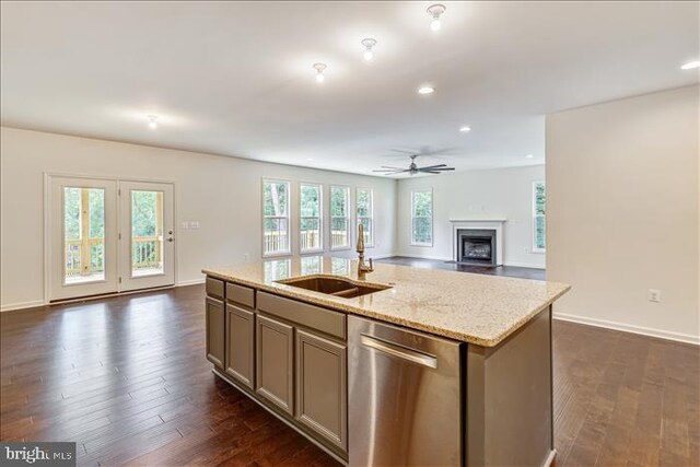 kitchen with a sink, a kitchen island with sink, dishwasher, ceiling fan, and open floor plan