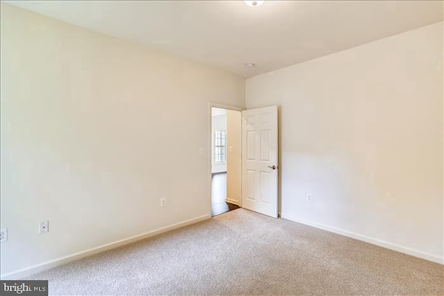 unfurnished room featuring carpet flooring and baseboards