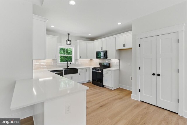 195 Promise Ln, Bumpass, VA 23024 - kitchen with black appliances, a sink, a peninsula, backsplash, and light countertops