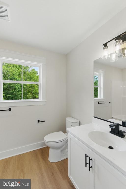 195 Promise Ln, Bumpass, VA 23024 - full bath with wood finished floors, vanity, toilet, and baseboards