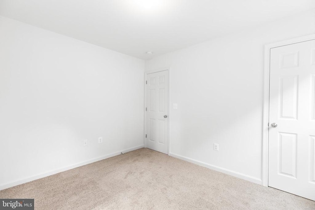 empty room with baseboards and light colored carpet