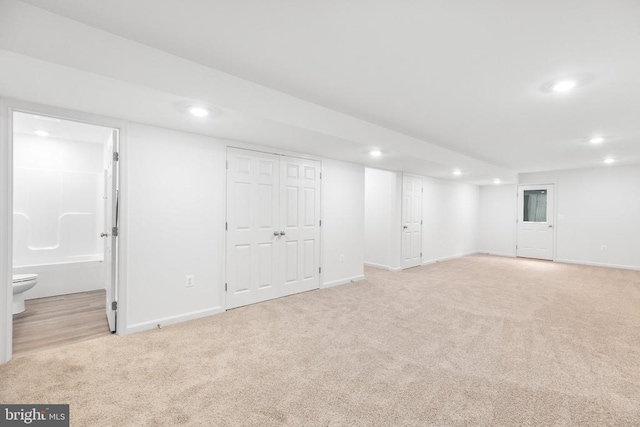 finished below grade area with recessed lighting, light colored carpet, and baseboards