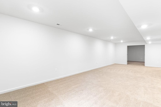 basement with light carpet, recessed lighting, and baseboards