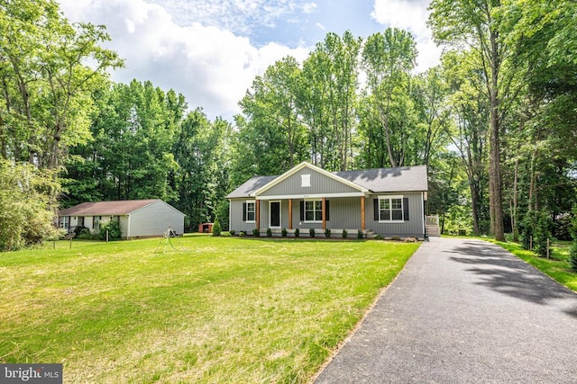 ranch-style house featuring a porch, driveway, and a front lawn