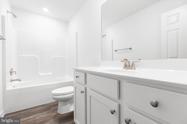 bathroom with toilet, tub / shower combination, wood finished floors, and vanity