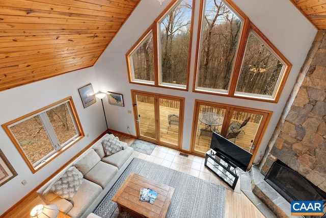 living area with baseboards, tile patterned flooring, high vaulted ceiling, and wooden ceiling