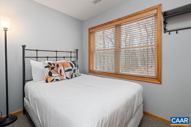 bedroom with carpet floors, baseboards, and visible vents